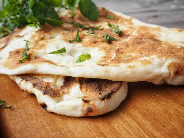 Ahşap arka plan üzerinde geleneksel Hint naan ekmek görünümü Kapat