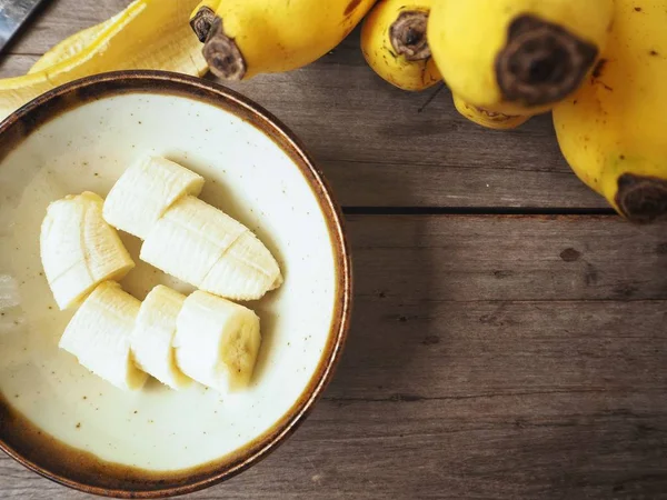 Muz dilimleri kase ahşap arka plan üzerinde