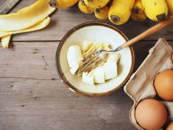 Ahşap arka plan üzerinde yumurta ile püre muz