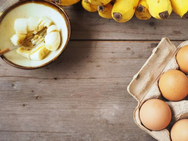 Ahşap arka plan üzerinde yumurta ile püre muz