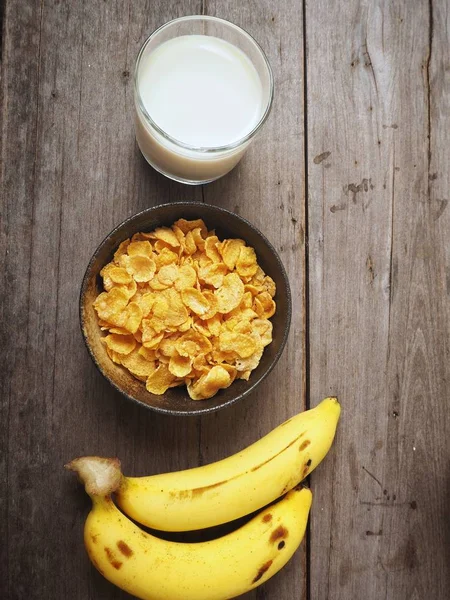 Mısır gevreği süt ve muz ahşap arka plan üzerinde üstten görünüm