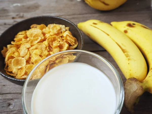 Mısır gevreği ahşap arka plan üzerinde muz ile servis görünümü Kapat