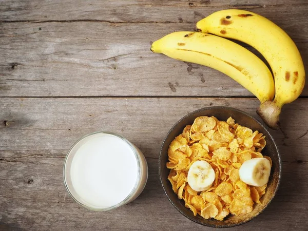 Mısır gevreği süt ve muz ahşap arka plan üzerinde üstten görünüm