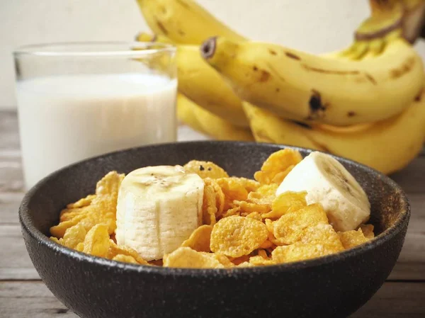 Mısır gevreği ahşap arka plan üzerinde muz ile servis görünümü Kapat