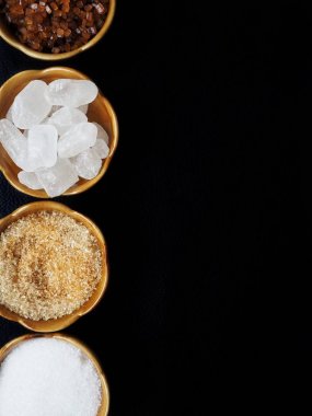 Bambu kase siyah arka plan üzerine beyaz ve kahverengi şeker