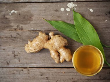 Zencefil çayı zencefil kökü ve ahşap zemin üzerine yeşil yaprakları ile