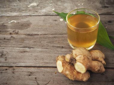 Zencefil çayı zencefil kökü ve ahşap zemin üzerine yeşil yaprakları ile