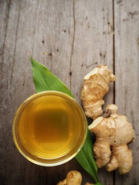 Zencefil çayı zencefil kökü ve ahşap zemin üzerine yeşil yaprak ile