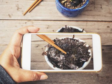 Ahşap arka plan üzerinde Kore deniz yosunu ile Smartphone