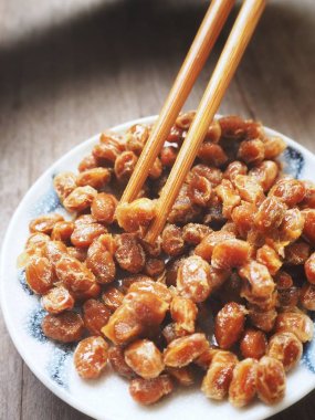 Geleneksel Japon gıda Natto ahşap arka plan üzerinde yemek çubukları ile