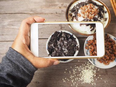Natto pirinç pişmiş ve smartphone ile fotoğraf çekici