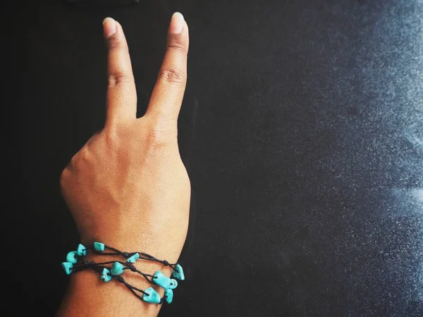 Tiro Recortado Mão Feminina Com Pulseira Mostrando Sinal Vitória — Fotografia de Stock