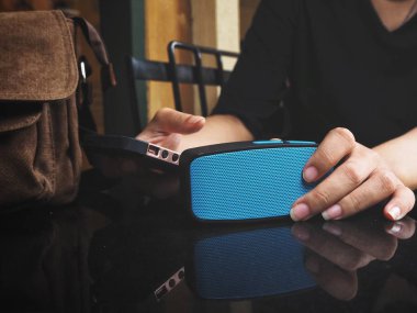 Bluetooth hoparlör ile akıllı telefon kullanan kadın