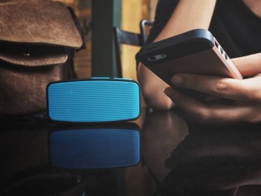 Bluetooth hoparlör ile akıllı telefon kullanan kadın