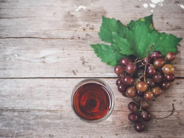 Fresh grape juice with ripe grape on wooden background