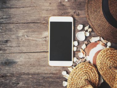 Flip flop ve kabukları ahşap arka plan üzerinde şapkalı sahip