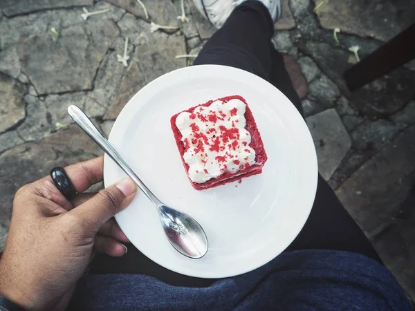 手拿一块蛋糕红色天鹅绒的人 — 图库照片