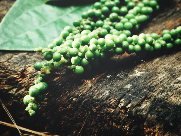 Peppercorns sobre fondo de madera —  Fotos de Stock