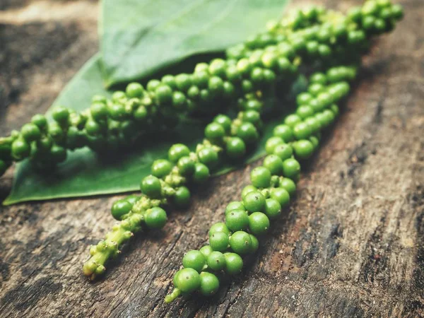 Peppercorns sobre fondo de madera —  Fotos de Stock