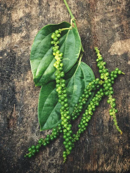 Peppercorns sobre fondo de madera —  Fotos de Stock