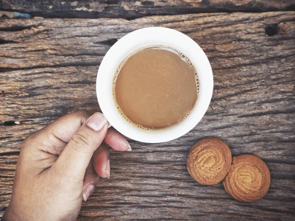 Чашка горячего кофе и печенье на деревянном фоне — стоковое фото
