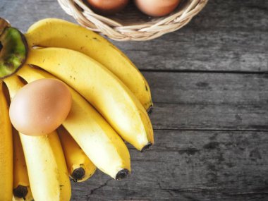 Ahşap zemin üzerinde muz ve yumurta.