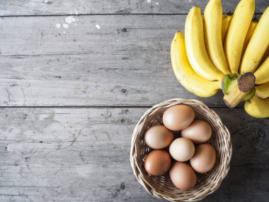 Ahşap zemin üzerinde muz ve yumurta.