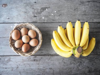Ahşap zemin üzerinde muz ve yumurta.