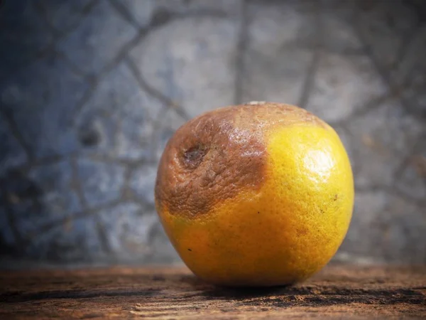 Rotten orange on wood background — 스톡 사진