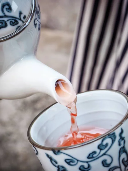 Menuangkan teh panas naik di cangkir dengan pot — Stok Foto