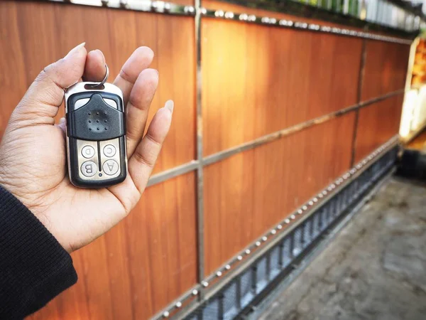 Opening automatic gate door with remote controller on hand