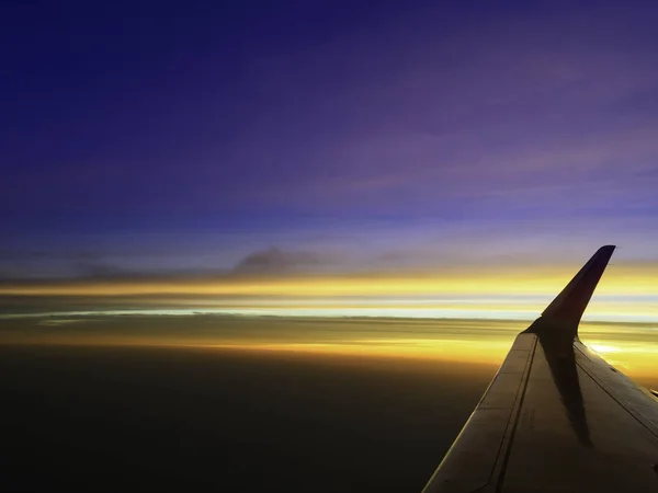 Beautiful twilight cloud sky through airplane wing — Stock Photo, Image