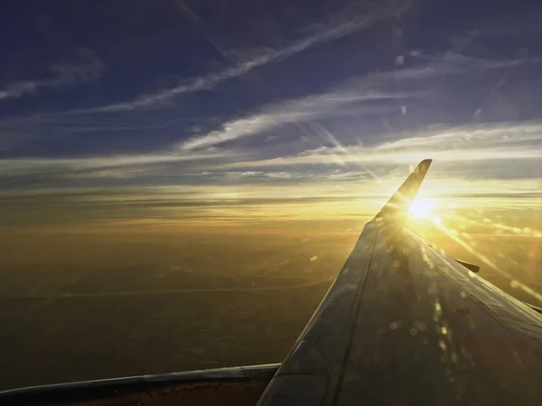 Sun set on horizon cloud sky  through airplane wing — Stock Photo, Image