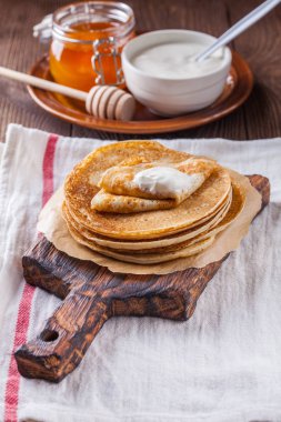 Bir yığın krep ekşi krema ve ballı Maslenitsa için