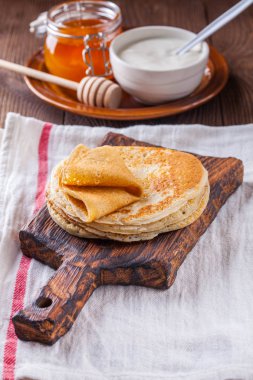 Bir yığın krep ekşi krema ve ballı Maslenitsa için