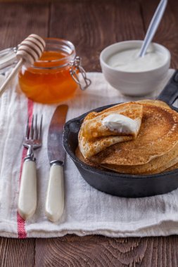 Bir yığın krep ekşi krema ve ballı Maslenitsa için