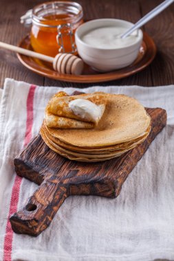 Bir yığın krep ekşi krema ve ballı Maslenitsa için