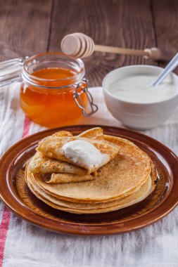 Bir yığın krep ekşi krema ve ballı Maslenitsa için