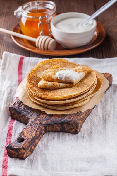 Bir yığın krep ekşi krema ve ballı Maslenitsa için