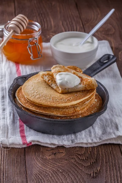 Bir yığın krep ekşi krema ve ballı Maslenitsa için