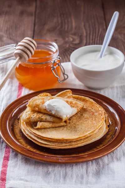 Bir yığın krep ekşi krema ve ballı Maslenitsa için