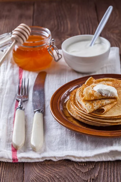 Bir yığın krep ekşi krema ve ballı Maslenitsa için