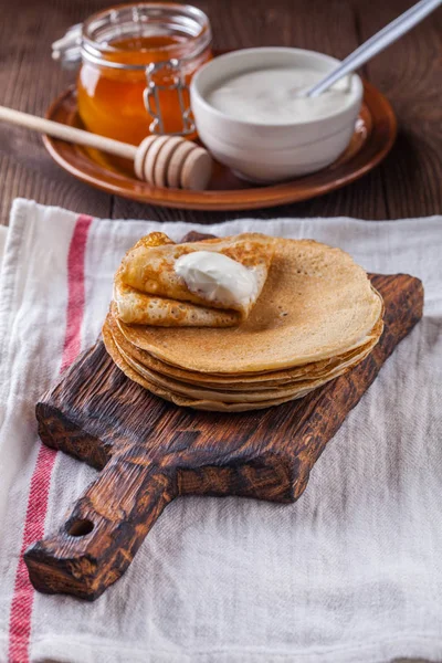 Bir yığın krep ekşi krema ve ballı Maslenitsa için