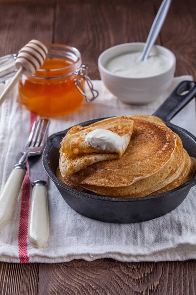 Een stapel pannenkoeken met zure room en honing voor Maslenitsa — Stockfoto