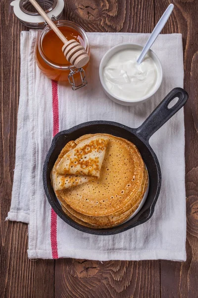 Een stapel pannenkoeken met zure room en honing voor Maslenitsa — Stockfoto