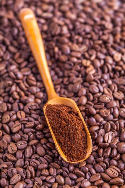 wooden spoon with ground coffee beans background