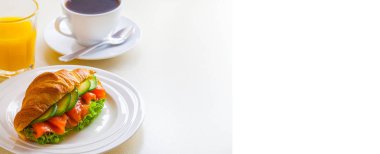 kruvasan sandviç somon ve avokado, kahve ve portakal suyu üzerinde beyaz bir arka plan ile