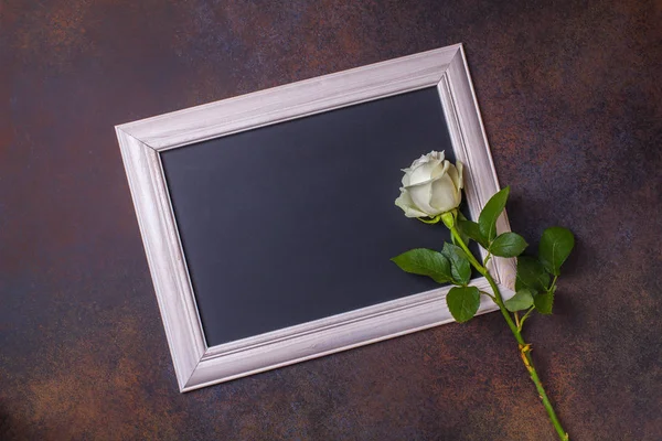 Black chalk board And white roses on a brown background, copyspace, horizontal Royalty Free Stock Photos