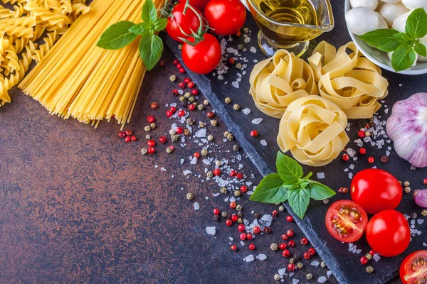 Ingredientes para pasta con mozzarella y tomates sobre fondo oscuro, horizontalmente, copyspace —  Fotos de Stock