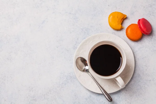 Weiße Tasse mit Kaffee, Makkaroni auf grauem horizontalen Hintergrund — Stockfoto